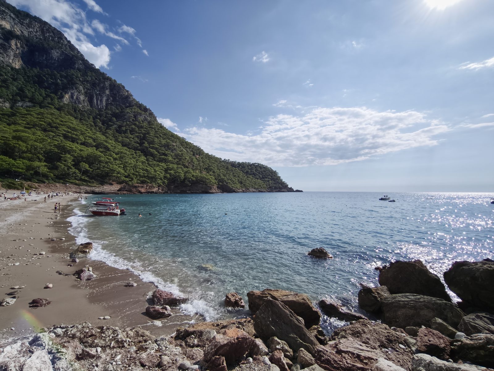 Kabak Koyu'nun kıyıdan görünümü, ormanla kaplı dağlar ve turkuaz deniz